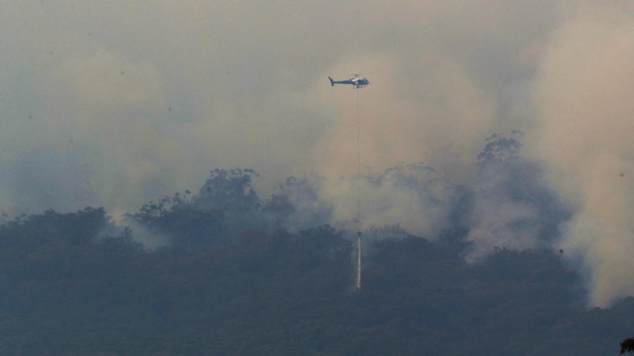 Helicopters drop water on a bushfire near Yiinnar in Gippsland. Picture: AAP