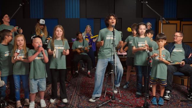 Singer Budjerah (centre), Johnny Ruffo (right), and seven children from the Starlight Foundation perform a Christmas carol. Photo: Supplied/Amazon.