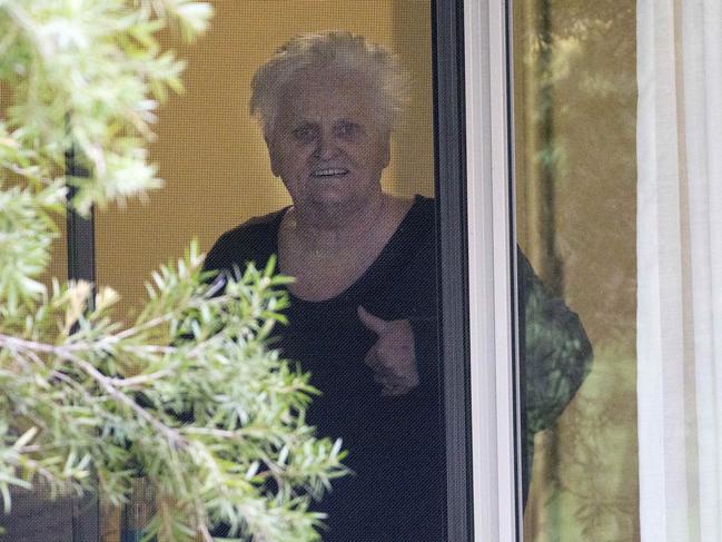 Patricia Shea, who is COVID-19 positive gives the thumbs up to her son from the window of her accommodation at Newmarch House. Picture: Damian Shaw.