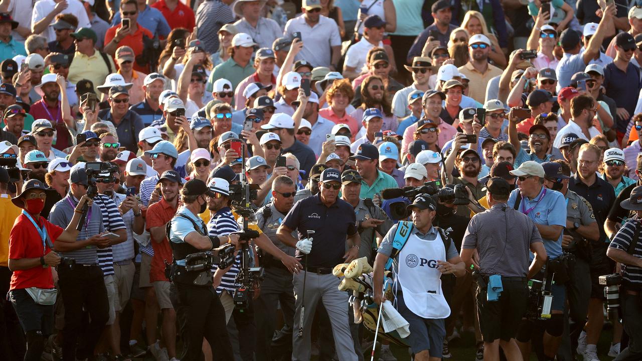 Phil Mickelson is mobbd by a crowd of fans as he walks up the 18th fairway during the final round of the 2021 PGA Championship.