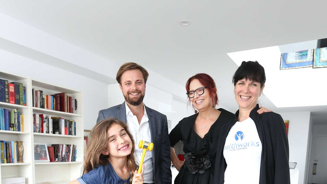 HAMMER TIME: Gabby Dobbin-Lavery, 8, with Ray White Mooloolaba agent James Goldsworthy's gavel, and new home owner Tracy Dobbin with her sister and Gabby's mum, Kelly Dobbin.