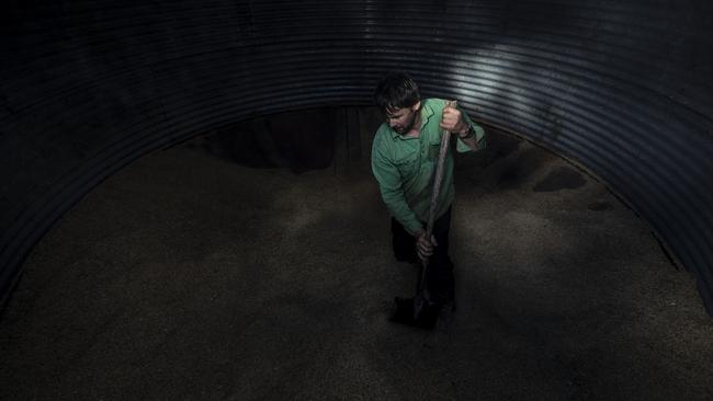 Farmer Robert Taylor scrapes the last of the grain stores out to feed livestock. Picture: Getty