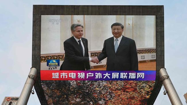 A China Central Television news broadcast shows footage of US Secretary of State Antony Blinken (L) meeting with China's President Xi Jinping, on a giant screen outside a shopping mall in Beijing. Picture: AFP.