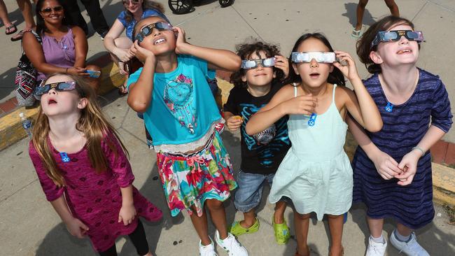 Children look at the sky during a partial solar eclipse. Picture: Bruce Bennett/Getty Images/AFP