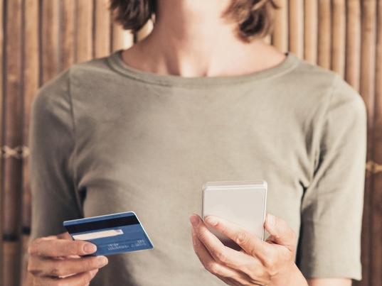 ESCAPE: ADVICE_ANNUAL TRAVEL INSURANCE, Sarah Nicholson -17FEB19. Young woman on vacations using phone and credit card. Online shopping concept Picture: iStock