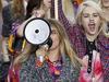 British model Cara Delevingne speaks through a megaphone (R) as she fakes a demonstration along with other models as they present creations for Chanel during the 2015 Spring/Summer ready-to-wear collection fashion show, on September 30, 2014 at the Grand Palais in Paris. AFP PHOTO / PATRICK KOVARIK