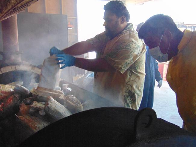 Marshall Islands Police emptying one-kilo packages of cocaine into an incinerator in Majuro from an 18-foot fibreglass boat washed up on Ailuk Atoll. Picture: AFP