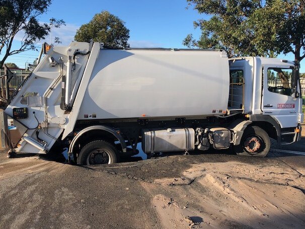 A garbage truck has got stuck in a sinkhole in Namona St, narrabeen. Picture: Jim O'Rourke.