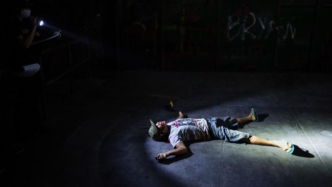 A police officer investigating a crime scene where an alleged drug dealer was gunned down by unidentified men in Manila. Picture: AFP / Noel Celis.