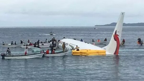 FILE - In this Sept. 28, 2018, file photo, local fishing boats move in to recover the passengers and crew of Air Niugini flight following the plane crashing into the sea on its approach to Chuuk International Airport in the Federated States of Micronesia. The airline operating a flight that crashed into a Pacific lagoon on Friday in Micronesia now says that one man is missing, after earlier saying that all 47 passengers and crew had safely evacuated the sinking plane. (James Yaingeluo via AP, File)