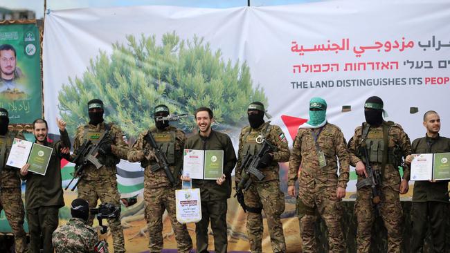 Hamas militants parade newly-released Israeli hostages, from left, Elia Cohen, Omer Shem Tov and Omer Wankert. Picture: AFP