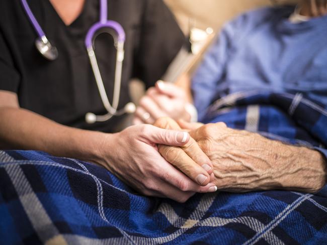 A stock photo of a Hospice Nurse visiting an Elderly male patient who is receiving hospice/palliative care. old age. Istock