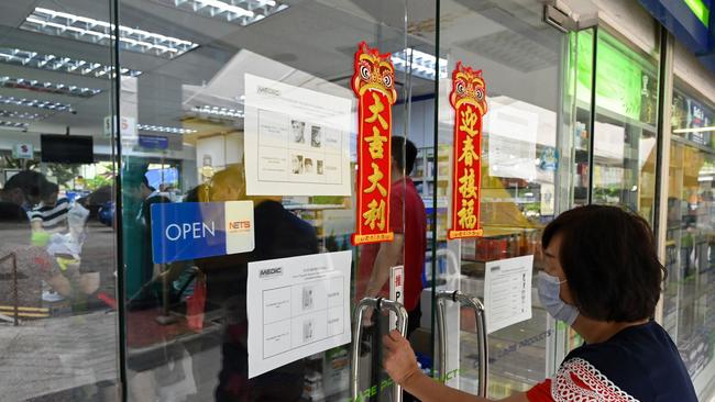 People queue at a pharmacy to by protective face masks, thermometers and hand sanitiser in Singapore, where there are so far seven confirmed cases of the coronavirus. Picture: Roslan Rahman/AFP