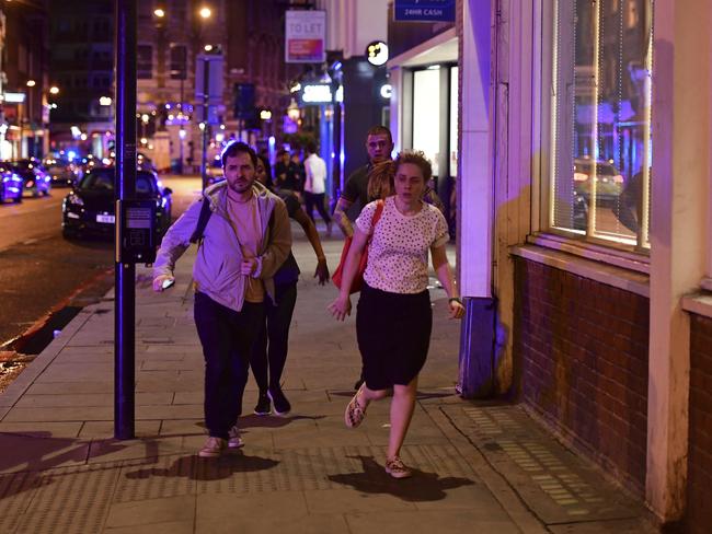 People run down Borough High Street as police deal with a ‘major incident’ at London Bridge. Picture: Dominic Lipinski/PA via AP