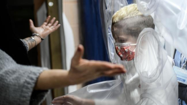 A boy patient prepares to hug his mother through plastic protection at the San Raffaele hospital in Rome. Picture: AFP