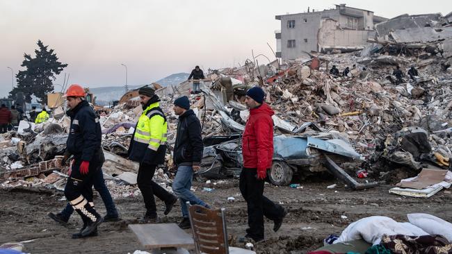 People walk past a collapsed building. Picture: Getty Images.