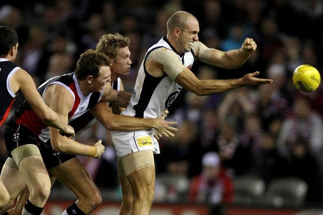 Chris Judd clears despite pressure from Saints players at Etihad.