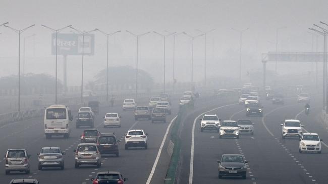 People commute along a road amid smoggy conditions in New Delhi.