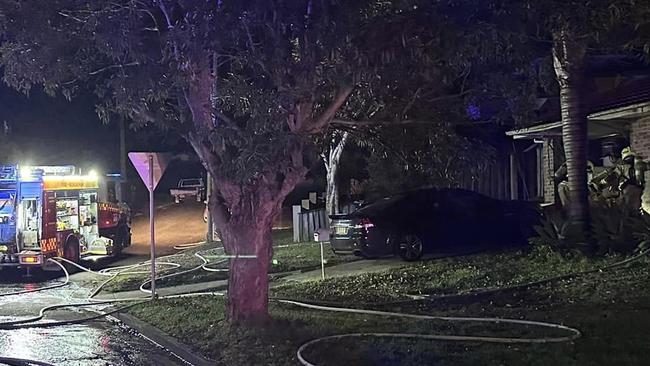 Firefighters (right) battle to save a house destroyed by fire in Ronald Ave, Narraweena, on Thursday morning. Investigators say a recharging lithium-ion battery for an e-scooter was likely the cause of the blaze. Picture: Belrose Rural Fire Brigade