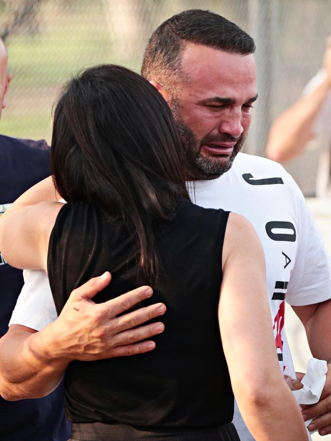 The father of three of the children, Daniel Abdallah, hugs a friend. Picture: Adam Yip