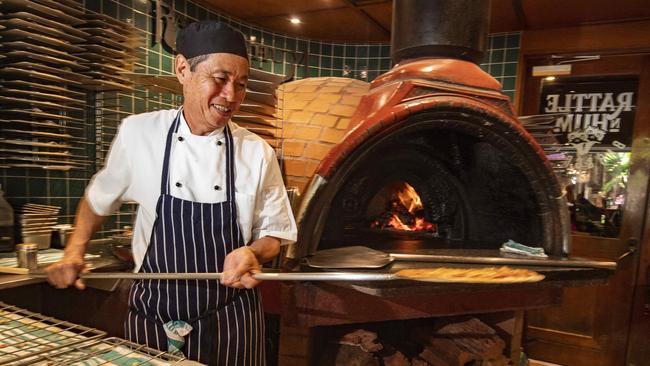 Rattle ‘n’ Hum pizza chef Sam Leong takes a fresh pizza form the pub's ceramic wood fired pizza oven. Picture: Brian Cassey