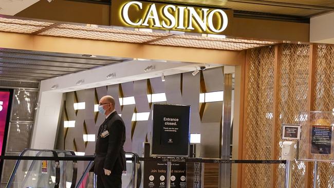 A security guard patrols a closed entrance outside Crown Casino today. Picture: AAP Image/Scott Barbour