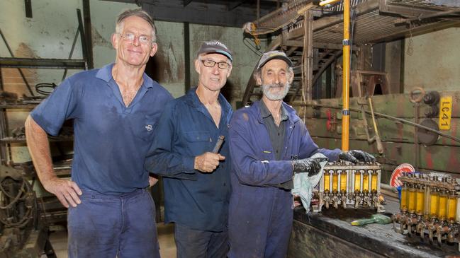 Volunteers Carl Heydon (left), Karl Worrall, and Vic Florey cleaning parts for the engines at the workshop in the power station.