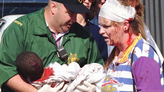 Sheriff Dept. personnel assist a child and woman injured in the bomb blast. Picture: Steve Gooch.