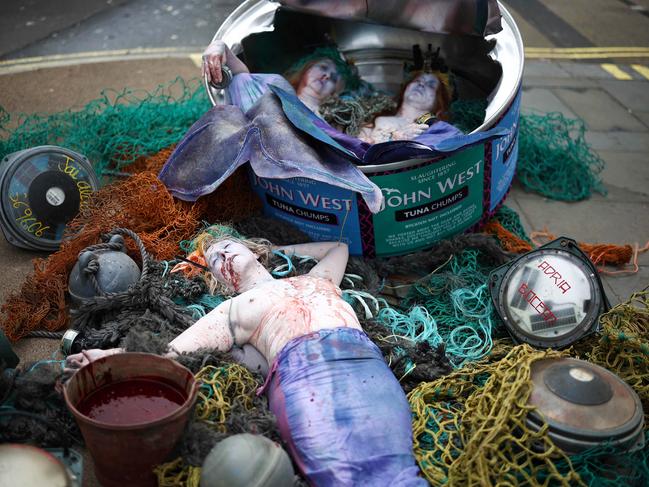 Ocean Rebellion activists lie inside a giant John West tuna tin outside a supermarket in London, during a protest against deadly industrially-caught fish. Picture: Henry Nicholls/AFP