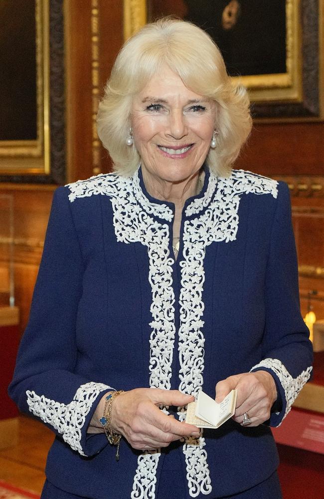 Queen Camilla holds a miniature book she received during a reception at Windsor Castle. Picture: Getty Images