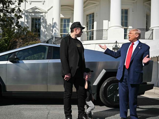 (FILES) US President Donald Trump and Tesla CEO Elon Musk speak to the press as they stand next to a Tesla Cybertruck on the South Portico of the White House on March 11, 2025 in Washington, DC. During his time as US President Donald Trump's controversial cost-cutting billionaire adviser, Elon Musk grabbed nearly as much media attention as the US president. With Musk's Tesla car company taking a battering on the stock market and sales dropping sharply, and with vandalism attacks targeting his brand, Musk marshalled Trump behind the wheel of a Model S and in front of a Cybertruck to defend the brand, turning the White House into a Tesla showroom. (Photo by Mandel NGAN / AFP)