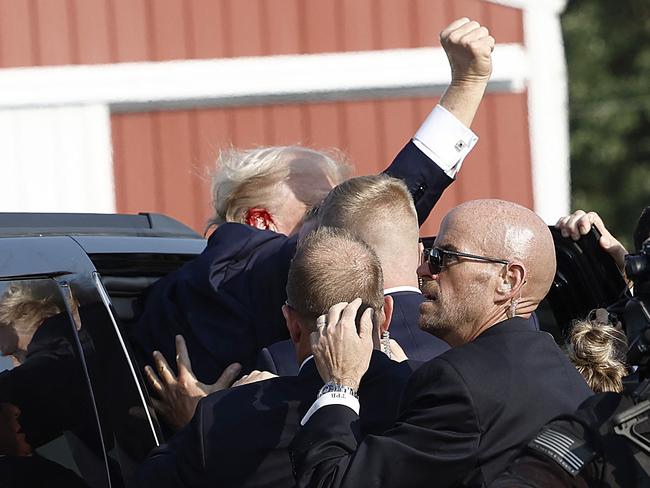 BUTLER, PENNSYLVANIA - JULY 13: Republican presidential candidate former President Donald Trump pumps his fist as he is rushed into car after an incident at a rally on July 13, 2024 in Butler, Pennsylvania.   Anna Moneymaker/Getty Images/AFP (Photo by Anna Moneymaker / GETTY IMAGES NORTH AMERICA / Getty Images via AFP)