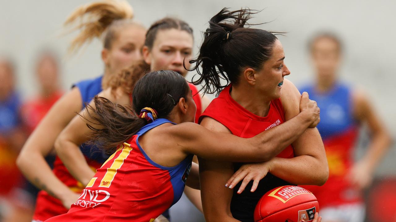 Sinead Goldrick of the Demons is tackled by Courtney Hodder.