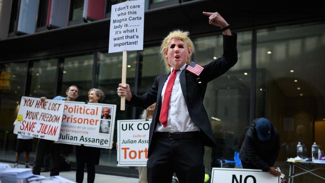 A man wears a Donald Trump mask as supporters of the WikiLeaks founder Julian Assange gather outside London’s Old Bailey court on Monday. Picture: Getty Images