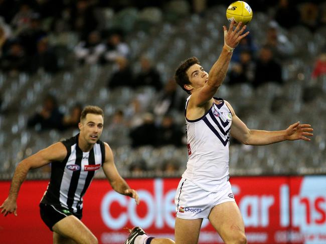 Collins, in one of his few AFL outings, marks in front of Collingwood's Steele Sidebottom. Picture: Colleen Petch