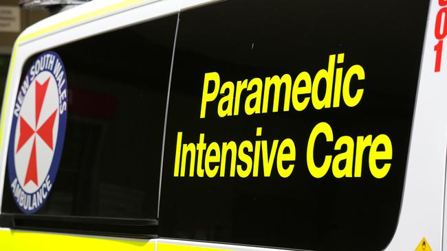 Ambulance paramedics and NSW Fire and Rescue officers worked to free the woman pinned by the arm against a tree by her own car in a bush reserve at North Narrabeen. Picture: NCA Newswire/Gaye Gerard