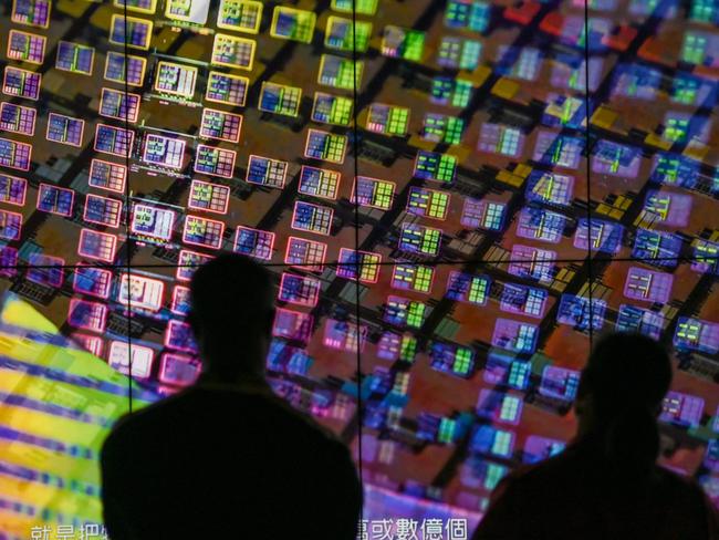 (FILES) Visitors watch a wafer shown on screens at the Taiwan Semiconductor Manufacturing Company (TSMC) Renovation Museum at the Hsinchu Science Park in Hsinchu on July 5, 2023. Taiwanese semiconductor giant TSMC announced on May 10, 2024 that its April earnings had jumped nearly 60 percent when compared to the same month a year ago. (Photo by Sam Yeh / AFP)