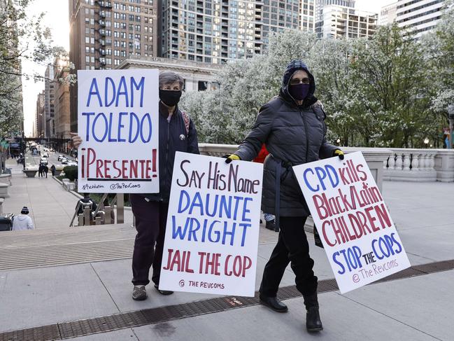 Women walk with signs through the Millennium Park as they protest killing of 13-year-old Adam Toledo by a Chicago Police officer on April 15. Picture: AFP