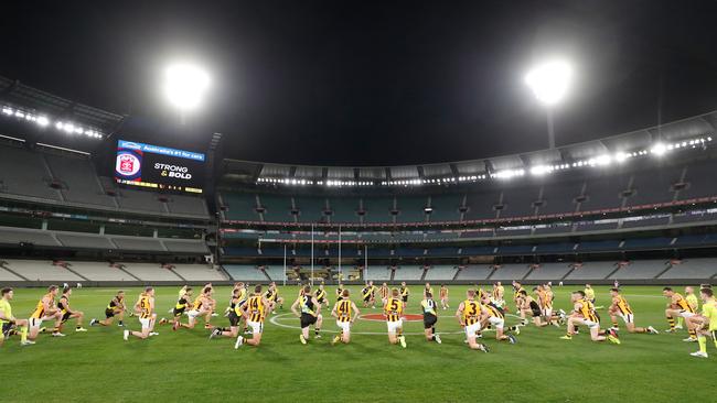 Players from Richmond and Hawthorn and umpires take a knee in a show of support for indigenous people facing racism in the AFL and broader community. Picture: Getty Images