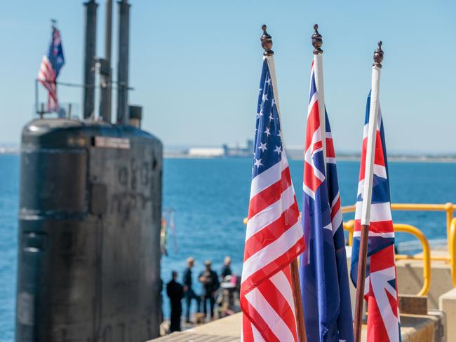 National flags of the USA, Australia and Great Britain are seen in front of the USS Asheville, a Los Angeles-class nuclear powered fast attack submarine, at HMAS Stirling, Western Australia on Tuesday, March 14, 2023. Picture: NCA NewsWire / pool / Richard Wainwright