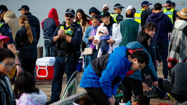 Police try to enforce social distancing rules before eventually closing Rye pier entirely. Picture: Mark Stewart