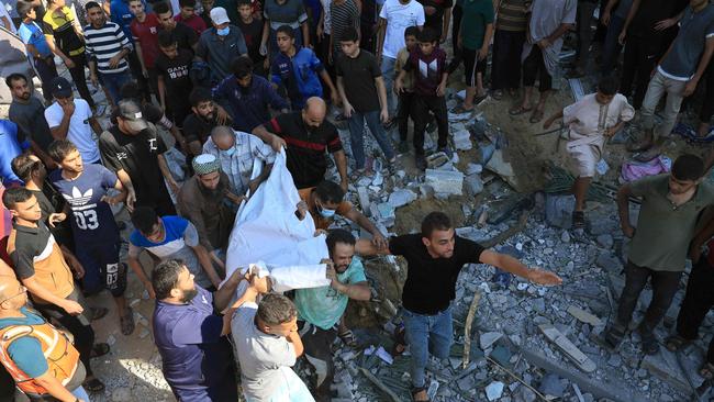 Palestinians carry a body brought out from under a collapsed building following an Israeli airstrike in Rafah, in the southern of Gaza Strip. Picture: AFP