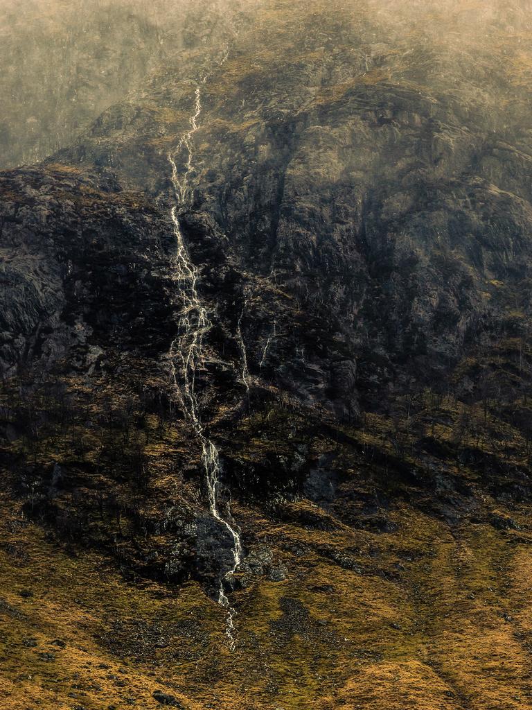 The Landscape Photographer of the Year: A Beginning and an End, Glencoe, Scotland by Mark Littlejohn — Landscape Photographer of the Year 2014 Extra information from photographer that can be used to support short caption ...’I’d got up at 1.30am to drive to Glencoe, meeting a couple of pals en route. Unfortunately, the rain was torrential at dawn and the water levels were the highest I’d ever seen them. We wandered about waiting for gaps in the weather and as we did, I saw this wee stream form high up on Gearr Aonach. It tumbled steeply down the slopes before vanishing again near the base of the mountain. With more squalls coming through I decided to take this image as the light became slightly more diffuse. It had to be a quick handheld shot due to the sideways rain.’ <a href="http://www.take-a-view.co.uk/" target="_blank">Find out more here. </a>