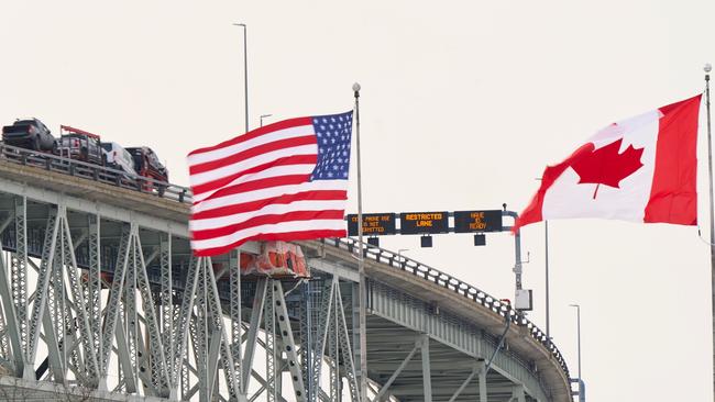 The US and Canadian flags fly on the US side of the St. Clair River near the Bluewater Bridge border crossing between Sarnia, Ontario and Port Huron, Michigan. Picture: AFP