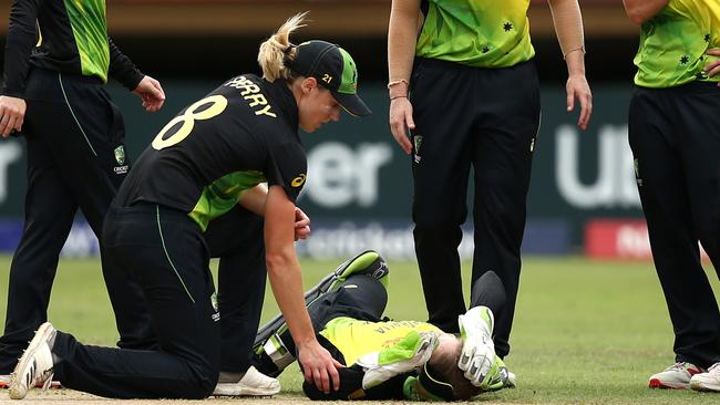 Ellyse Perry comes to the aide of friend Alyssa Healy after she collided with teammate Megan Schutt going for a catch. Picture: Getty