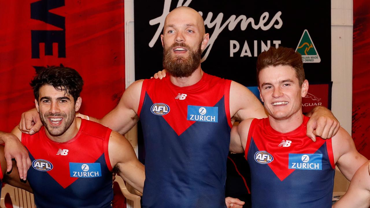 MELBOURNE, AUSTRALIA - APRIL 01: Christian Petracca, Max Gawn and Bayley Fritsch of the Demons sing the team song during the 2022 AFL Round 03 match between the Melbourne Demons and the Essendon Bombers at the Melbourne Cricket Ground on April 01, 2022 In Melbourne, Australia. (Photo by Dylan Burns/AFL Photos via Getty Images)