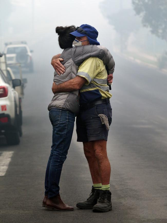 Cobargo local resident Shona Taranto, whose is the owner of a small business destroyed in the town’s Main Street, is comforted by Tim O'Mearo. Picture Gary Ramage