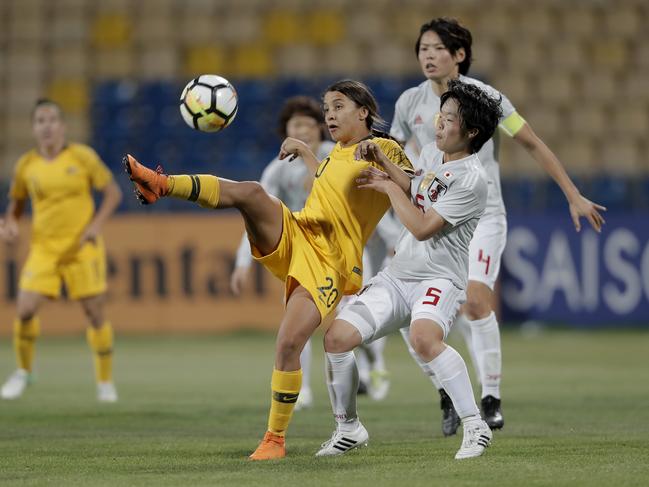 Australia's Samantha Kerr, left, fights for control of the ball against Japan's Nana Ichise