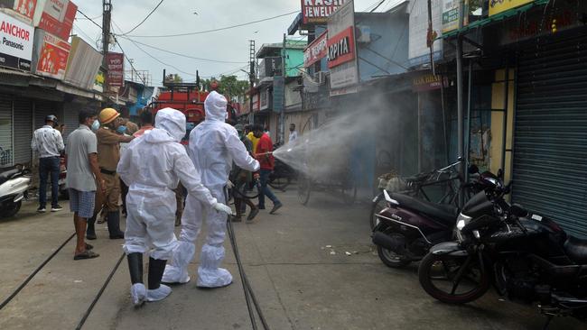 Firefighters wearing Personal Protective Equipment spray disinfectant in a closed market amid concerns over the spread of the COVID-19 in India. Picture: AFP