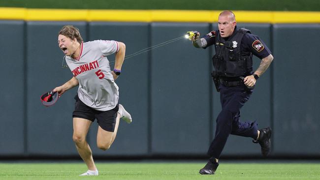 CINCINNATI, OHIO - JUNE 11: An unidentified fan is tased by a police officer as he runs on the field before the ninth inning of the Cincinnati Reds against Cleveland Guardians at Great American Ball Park on June 11, 2024 in Cincinnati, Ohio.   Andy Lyons/Getty Images/AFP (Photo by ANDY LYONS / GETTY IMAGES NORTH AMERICA / Getty Images via AFP)
